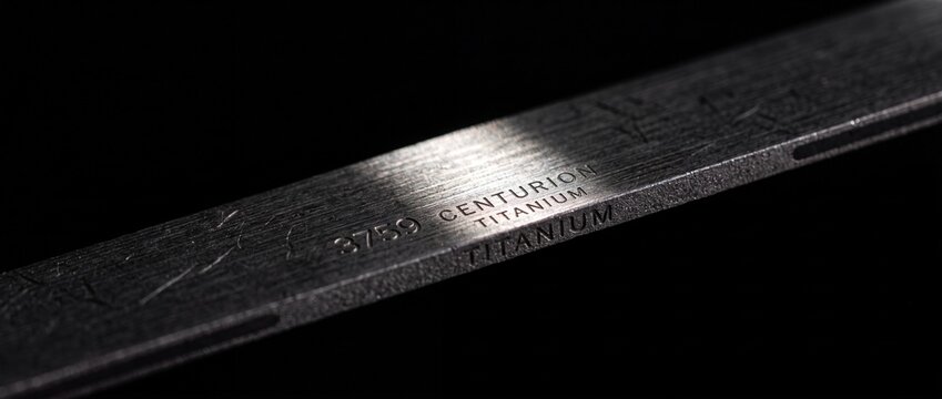 Brushed metal bar with engraved centurion titanium text and numeric serial number highlighting premium material quality and craft.