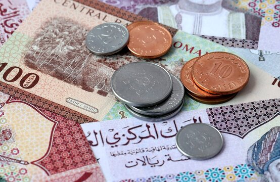 Omani rial money banknotes and coins on table. Oman cash bills of OMR currency close up