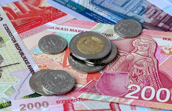 Uzbekistani som money banknotes and coins on table. Uzbekistan cash bills of UZS currency