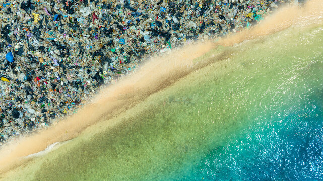 Polluted beach with plastic waste and garbage washed up on the shore, environmental pollution and ocean waste concept, ecological problem on tropical coast	

