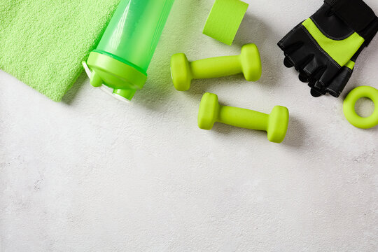 Green fitness gear and towel flat lay with copy space