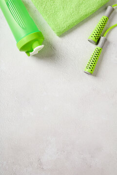 Vertical fitness background with green shaker jump rope and towel