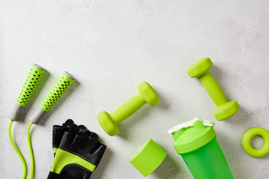 Green fitness accessories flat lay on grey stone table