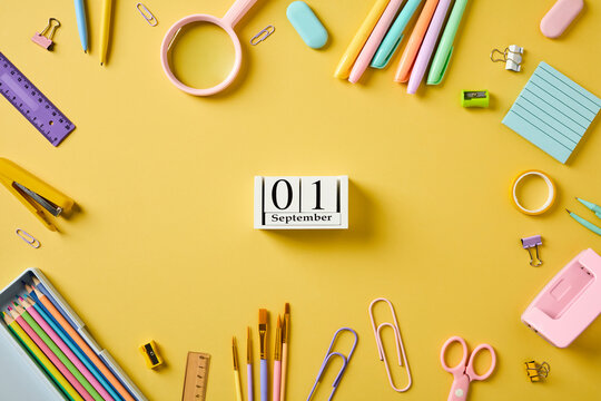 School supplies frame with September 1 block calendar on yellow background
