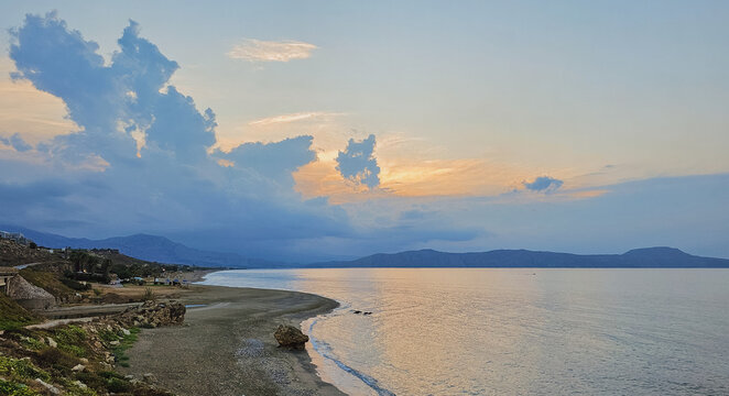 Scenic view of dramatic overcast cloudy sky over tranquil Mediterranean sea coast and beach in Crete Greece at evening dusk for travel nature stock photo background