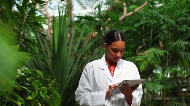 Female botanist researcher studying plants in a greenhouse