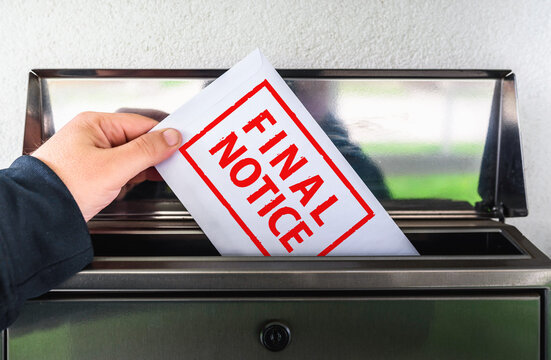 Person putting an envelope labeled Final Notice in a mailbox, late payment concept