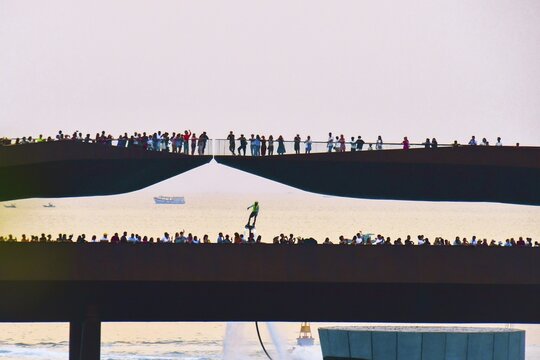 Phu quoc, Vietnam - 15th february, 2024: Crowd of spectators tourist on Kiss bridge during water show on Sunset town in Phu Quoc, Vietnam. Hoverboard show performance in public