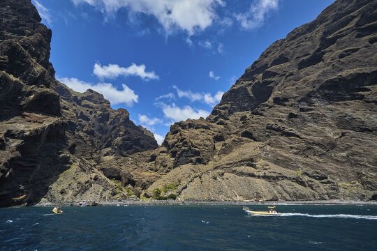 Exit of the Masca gorge, Los Gigantes, impressive rocky gorge with small boats on the sea under a cloudy sky, whale watching boat tour, whale watching, whales, dolphins, west coast, Tenerife, Canary Islands, Spain