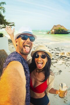 Playful couple taking funny beach selfie in Zanzibar Tanzania, tropical vacation, carefree travel lifestyle, Indian Ocean coastline, joyful holiday moments