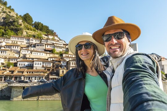 Portrait Joyful heterosexual couple looking at camera taking selfie photo laughing enjoying spring vacation get away holidays in Berat, Albania. Concept connection, happiness, freedom, fun, bonding