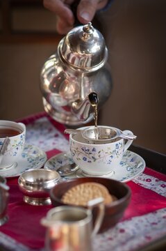 English tea is poured from an old teapot into a fine porcelain tea cup, traditional English afternoon tea, Chapslee Hotel, former summer residence of the Raja of Kapurthal, Elysium Hill, Lakkar Bazar, Shimla, Himachal Pradesh, North India, India