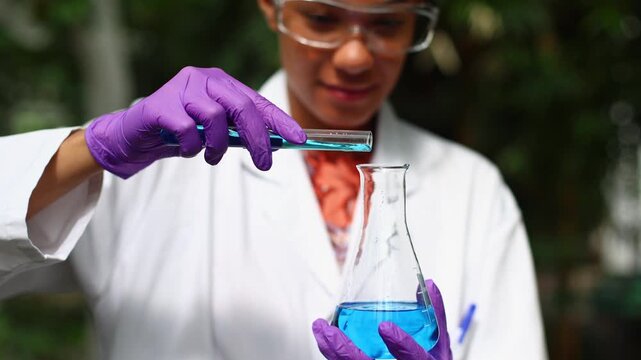 Female scientist mixing chemicals in laboratory flask