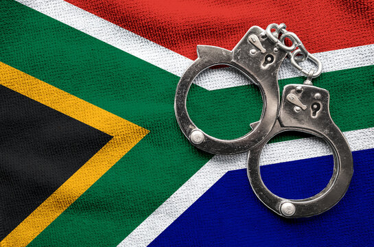 Flag of Flag of South Africa and police handcuffs. Crime and offenses in country Concept