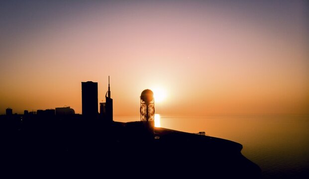 Panoramic silhouette of Batumi city skyscrapers from distance with blue sea water in the background. Georgiatravel iliustration concept. Batumi.Georgia