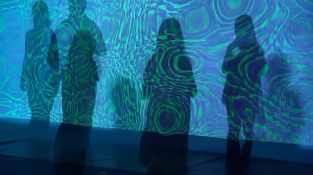 Silhouettes before blue green ripple projection in immersive exhibition space with translucent panel, layered wave patterns, soft backlight, subtle posture shifts, and glowing abstract atmosphere