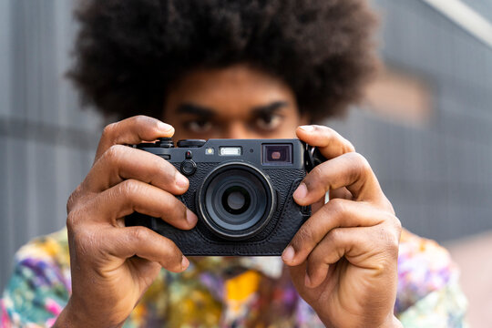 Close-up of man with a camera wearing colorful shirt