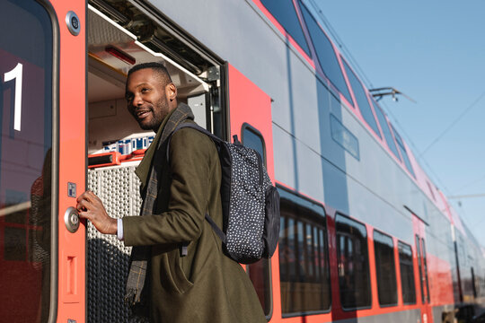 Portrait of stylish man entering a train