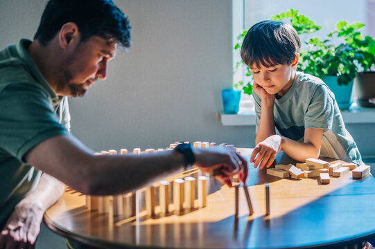 Dad and son playing with wooden blocks at home
