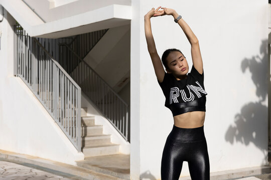 Woman stretching her arms outdoors before a fitness workout