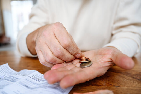 Man counting coins on hand at home