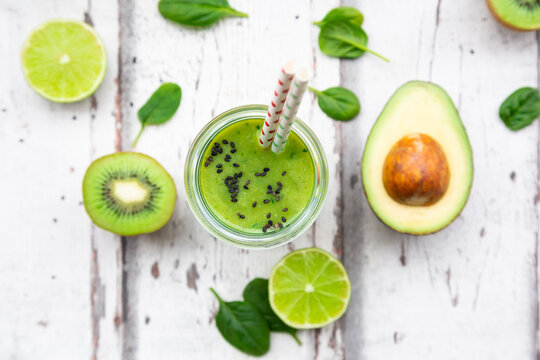 Glass of green smoothie with avocado, spinach, kiwi and lime