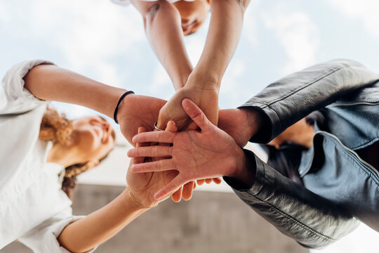 Young women stacking hands together