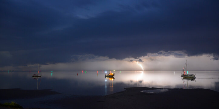 Heavy thunderstorm over a flatbottom ship in Wadden Sea at night