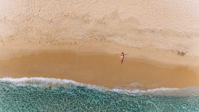 Woman relaxes on a sandy beach in Sardinia
