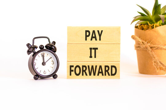 Pay it forward words symbol. Concept words Pay it forward on beautiful wooden blocks. Beautiful white background. Black alarm clock. Business and pay it forward concept. Copy space.