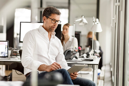 Businessman at desk in office using tablet