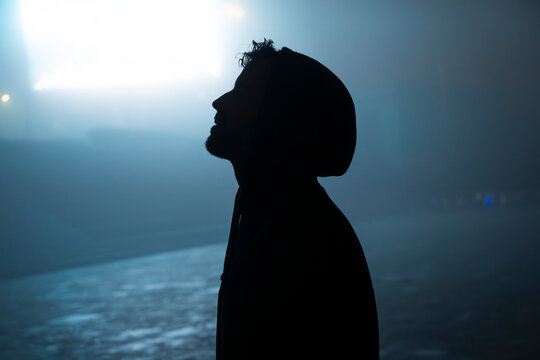 Dark silhouette looking up into mysterious fog and light in Sapa