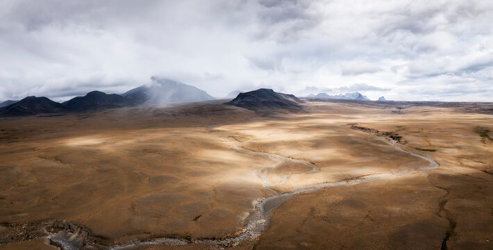 A glacial river weaves through the volcanic desert of Iceland