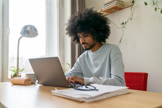 Focused freelancer working on laptop at home