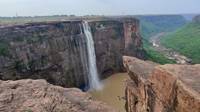 This waterfall drops over layered cliffs, where natural river flow and green vegetation enhance the beauty of the rugged terrain. Bahuti Falls, Rewa District, Madhya Pradesh, India.