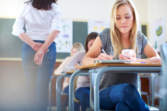 Female student in classroom cheating during an exam