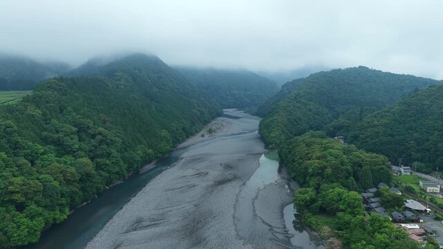 Aerial drone footage over river valley with mist in Shimada, Shizuoka, Japan