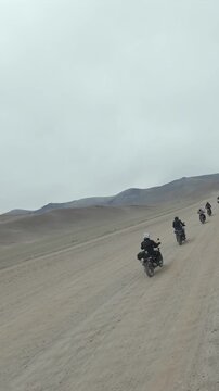 Vertical FPV Drone View of Adventure Motorcyclists Crossing Desert Plains in Ladakh