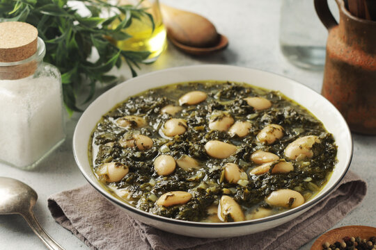 A bowl with traditional Tuscan kale salad and white beans soup Cavolo nero e fagioli	