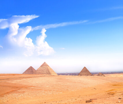 Famous Great Pyramids of Menkaure, Chephren and Cheops, Cairo, Egypt. Three iconic Great Pyramids and beautiful sand dunes, Giza Necropolis, have become a popular destination for travellers