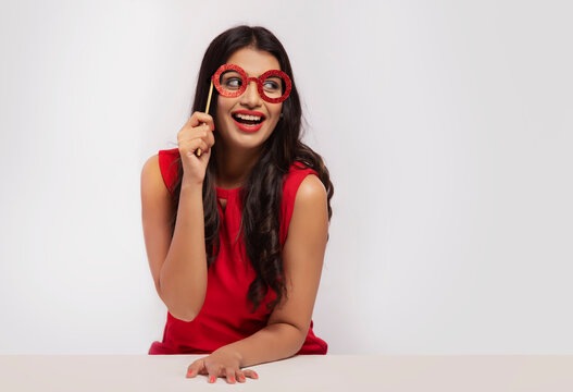 Portrait of a young woman with an eye mask prop.