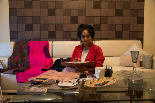 A middle aged fashion consultant working at home. 