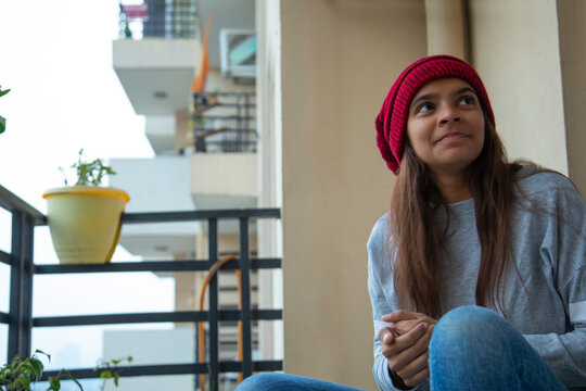 Young girl sitting in the balcony on a winter afternoon. (Children) 