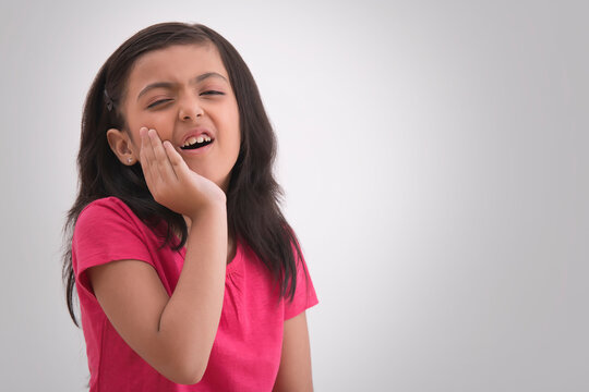 Young girl screaming in pain due to a toothache. (Children) 