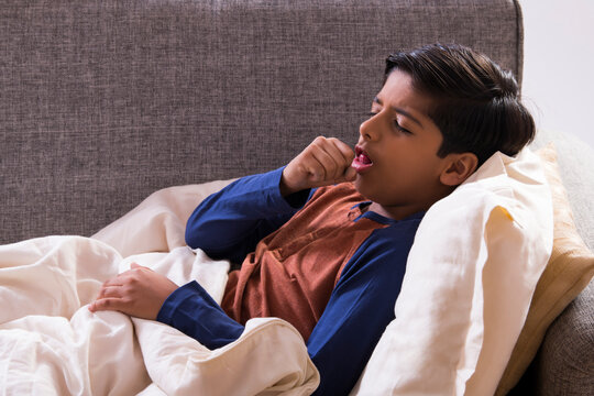 Young boy lying on the couch and coughing.(Children) 