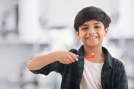Portrait of a young boy brushing his teeth. (Children) 
