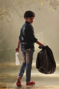 Young boy collecting garbage from the streets and helping the environment. (Children)