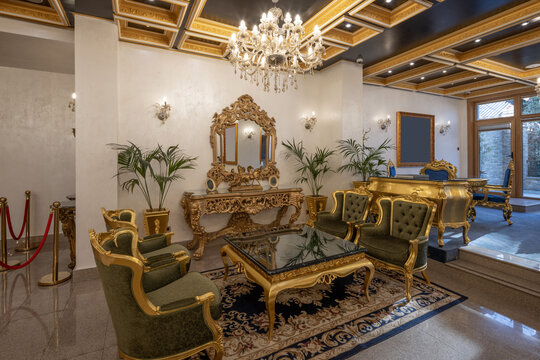 Luxurious hotel waiting area with golden furniture and velvet armchairs