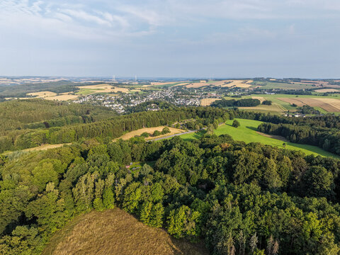 Aerial View of Rolling Forest and Farmland Landscape with Scenic Rural Village in the Distance