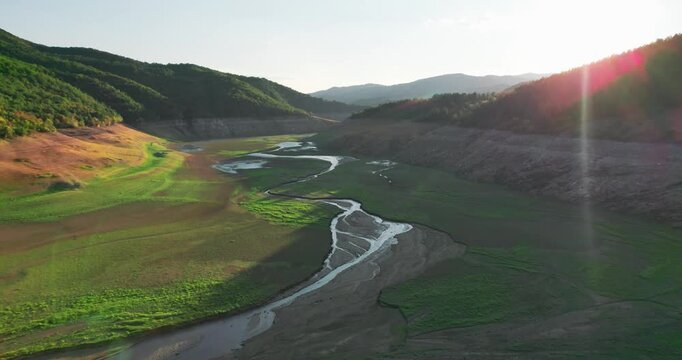 Drought Stricken Dam Lakebed with Empty Riverbed at Sunset